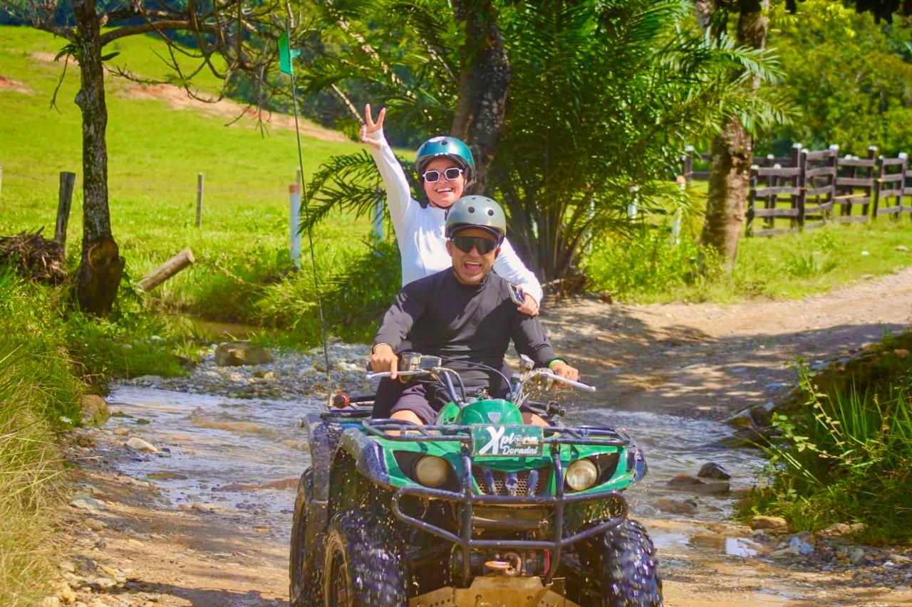 Pareja en tour de cuatrimoto cruzando charco en Doradal, aventura en pareja Antioquia Colombia